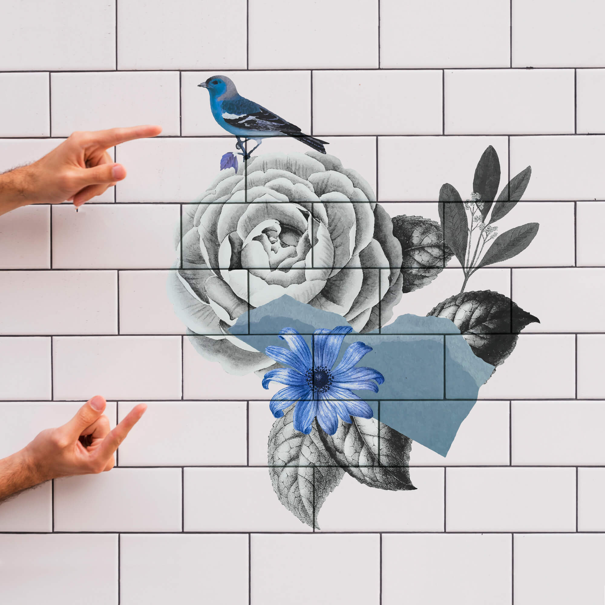 Imagen de una pared de baño blanca de azulejos rectangulares, con una impresión directa de unas flores y un pájaro, azúles y negras.
