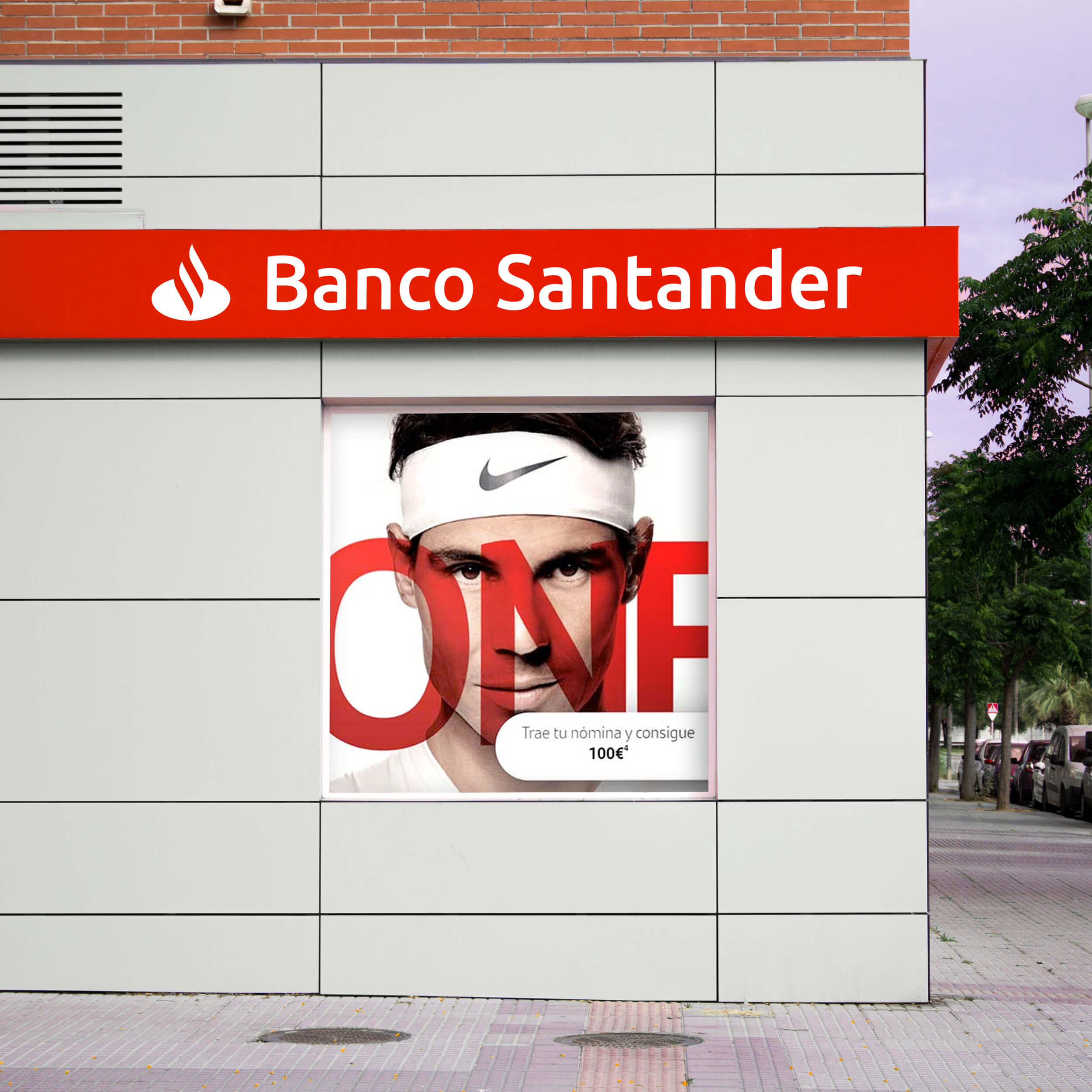 Imagen de la fachada del banco santander rotulada en el material dobond de color rojo, calada con luz led.