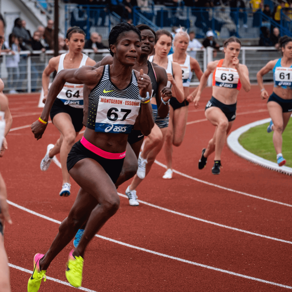 Imagen de una mujer de color corriendo una carrera olímpica con su dorsal colocado en el pecho.