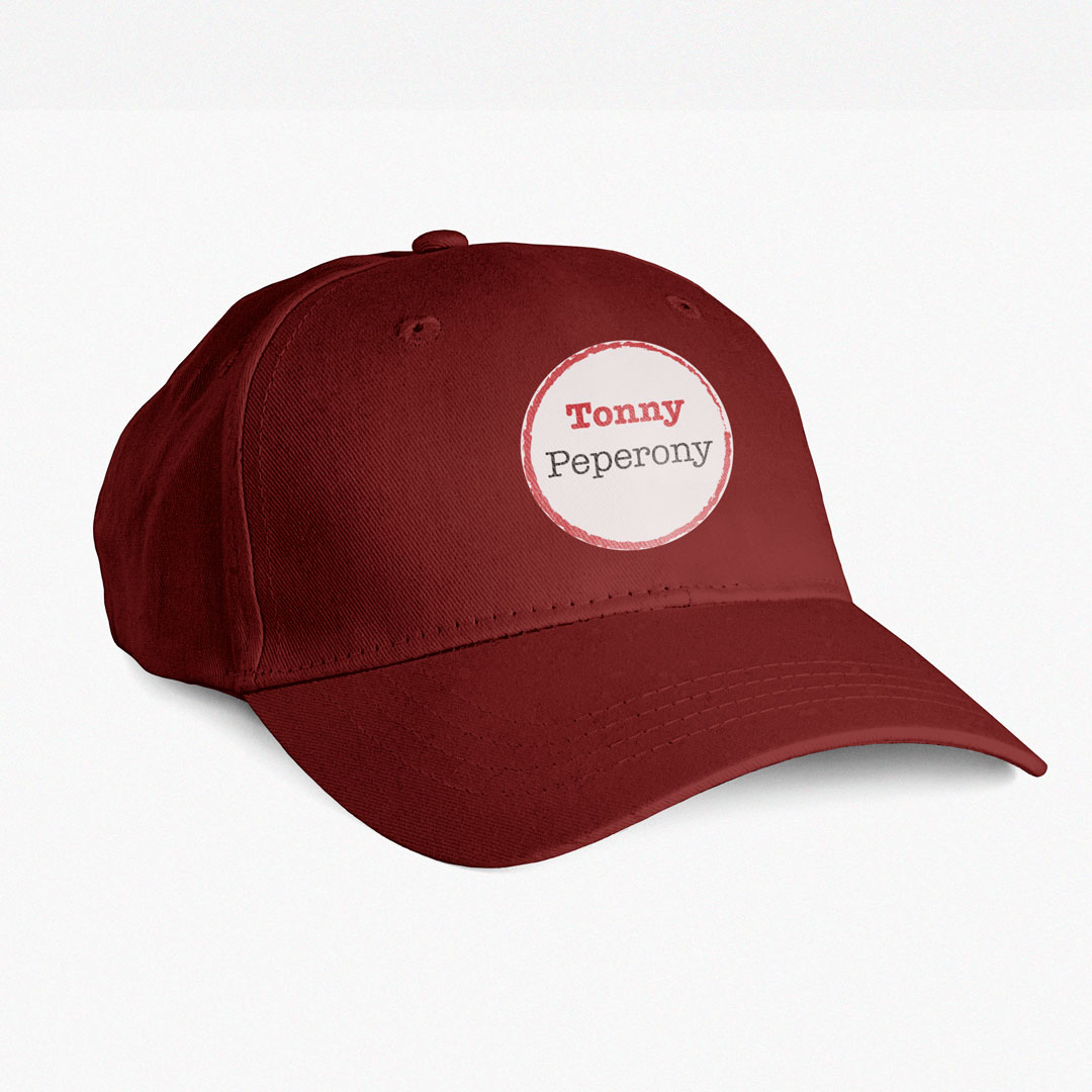 Imagen de la gorra roja de Tonny Peperony, rotulada con el logotipo de la pizzería en la parte delantera.
